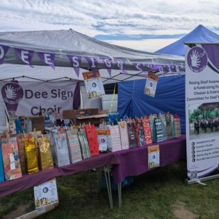 https://deesignchoir.co.uk/wp-content/uploads/2025/08/Dee-Sign-Choir-Stall-at-Cilcain-Summer-Fete.jpg