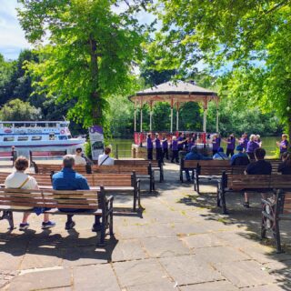 https://deesignchoir.co.uk/wp-content/uploads/2026/06/Signing-Islands-in-the-Stream-at-the-Bandstand-in-Chester.jpg